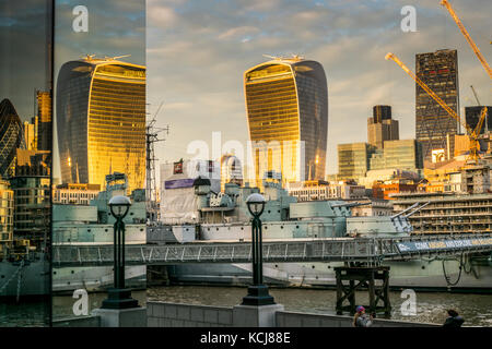 Golden Sunset Reflexion walkie talkie Gebäude im modernen verglasten Gebäude an der South Bank in London mit der HMS Belfast wiederholt Stockfoto