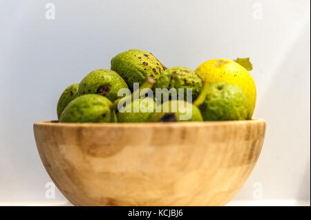 Grüne, frische Walnüsse in eine hölzerne Schüssel Stockfoto