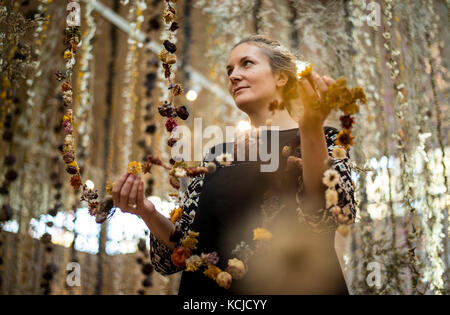 Die Künstlerin Rebecca Louise Law setzt den letzten Schliff für ihre neue Hängeinstallation "Life in Death" mit 375,000 Blumen in der Shirley Sherwood Gallery of Botanical Art, Teil von Artful Autumn in Kew Gardens im Südwesten Londons. Stockfoto