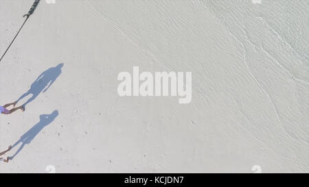 Schatten von Paaren am Strand. Langer Schatten junger Paare auf Strandsand. Süße Schatten eines frisch frisch verheirateten Ehepaares während ihrer Flitterwochen am Strand. Junge Lieben Paare Schatten Stockfoto