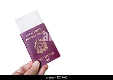Hand, die einen italienischen Pass mit einer Bordkarte innen über Weiß isoliert. Stockfoto