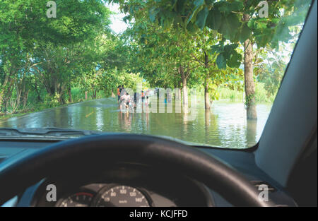 Auto fahren in schwerem Regen auf einer überfluteten Straße. Auto durch Hochwasser nach starken Regen. Stockfoto