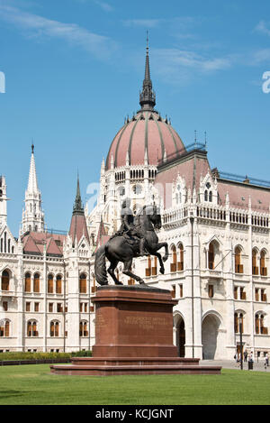 Die Statue von Ferenc Rakoczi vor dem ungarischen Parlamentsgebäude auf dem Kossuth Lajos Platz in Budapest an einem sonnigen Tag mit blauem Himmel. Stockfoto