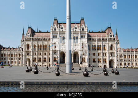 Der offizielle Haupteingang des ungarischen Parlamentsgebäudes am Kossuth Lajos Platz in Budapest an einem sonnigen Tag mit blauem Himmel. Stockfoto