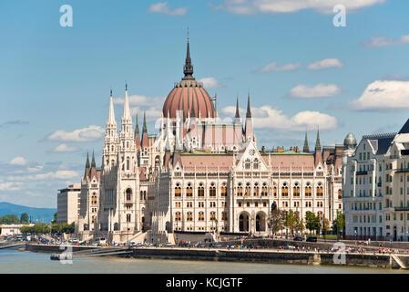 Ein Blick auf das ungarische Parlamentsgebäude an der Donau in Budapest an einem sonnigen Tag mit blauem Himmel. Stockfoto