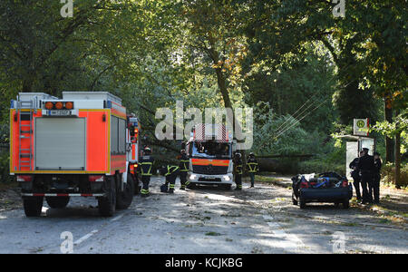 Hamburg, Deutschland. Oktober 2017. Polizeibeamte stehen neben dem beschädigten Auto in Hamburg, Deutschland, 5. Oktober 2017. Eine Frau starb im Sturm Xavier am 5. Oktober 2017. Laut einem Sprecher der Feuerwehr fiel ein Baum auf das Auto des Opfers im Bezirk Horn. Quelle: Christophe Gateau/dpa/Alamy Live News Stockfoto