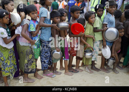 Oktober 4, 2017 - Cox's Bazar, Bangladesch - rohingya Flüchtlingskinder in Linie warten Essen in einem Flüchtlingslager in ukhiya zu sammeln. Nach Angaben der UNHCR mehr als 500.000 Rohingya-Flüchtlinge Myanmar von Gewalt im letzten Monat geflohen, die meisten versuchen, die Grenze zu überqueren und in Bangladesch. Credit: k m Asad/zuma Draht/alamy leben Nachrichten Stockfoto