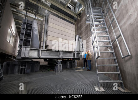 Ein Besucher und ein Mitarbeiter von ThyssenKrupp Elevators stehen neben dem 240-Tonnen-Schwingungsdämpfer, der sowohl das Gebäude vibrieren als auch vor Vibrationen schützen kann, während einer Presseroute anlässlich der Eröffnung des Prüfturms für Aufzüge von ThyssenKrupp in Rottweil, Deutschland, 06. Oktober 2017. Der Turm ist das höchste Gebäude in Baden-Württemberg und der Besuchersteig ist mit 232 Metern Höhe der höchste in Deutschland. Foto: Sebastian Gollnow/dpa Stockfoto