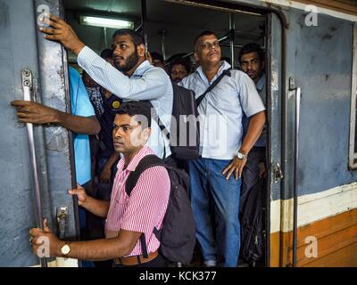 Colombo, Westprovinz, Sri Lanka. Oktober 2017. Männer fahren in Colombo in einem überfüllten Pendlerzug. Die Züge Sri Lankas bieten eine zuverlässige, kostengünstige Transportmöglichkeit für Menschen, die in die Hauptstadt Sri Lankas pendeln. Quelle: Jack Kurtz/ZUMA Wire/Alamy Live News Stockfoto