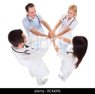 Portrait von Arzt stapeln ihre Hände zusammen über weißen Hintergrund Stockfoto