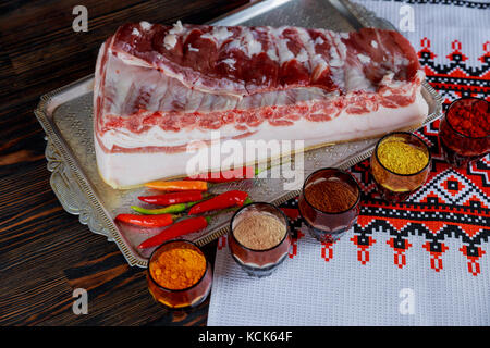 Frisches Schweinefleisch fett und Rippen mit Chili Tomaten und Paprika sowie Schimmel Gewürze Gewürze bereit für Grill auf schiefer Fach Stockfoto