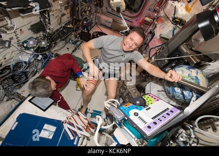 Die US-amerikanischen Astronauten Peggy Whitson (links) und Jack Fischer bereiten sich auf das Experiment Integrated Resistance and Aerobic Training Study im Columbus European Laboratory-Modul am 3. Mai 2017 in der Erdumlaufbahn vor 51. (Foto: NASA, Foto über Planetpix) Stockfoto