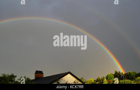 Ein doppelter Regenbogen über einem Haus in Krokstadelva, Norwegen gesehen Stockfoto