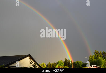 Ein doppelter Regenbogen über einem Haus in Krokstadelva, Norwegen gesehen Stockfoto