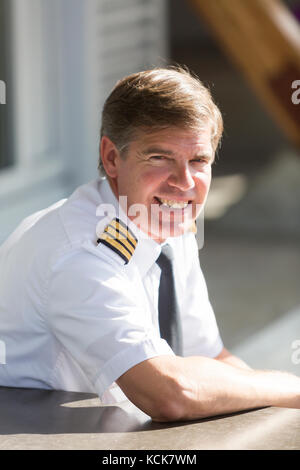 Eine Airline Pilot entspannt beim Warten auf eine Fahrt bei Comox yqq Flughafen, der Comox Valley, Vancouver Island, British Columbia, Kanada Stockfoto