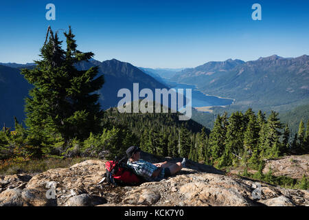 Ein einsamer Wanderer nimmt einen Bruch an der Blüte Ridge Wanderweg mit Blick auf buttle Lake im Strathcona Park, Strathcona Park, Central Vancouver Island, British Columbia, Kanada Stockfoto