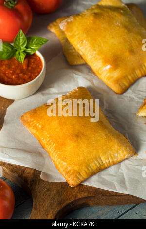 Hausgemachte Wurst pocket Pizza Calzone mit Käse und Marinara Stockfoto