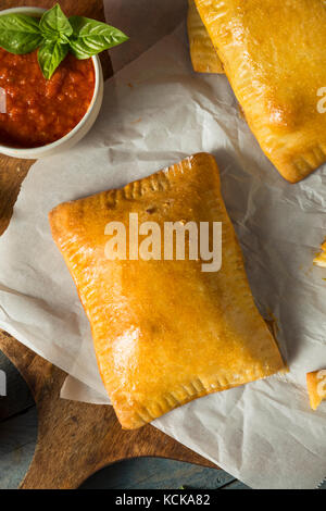 Hausgemachte Wurst pocket Pizza Calzone mit Käse und Marinara Stockfoto