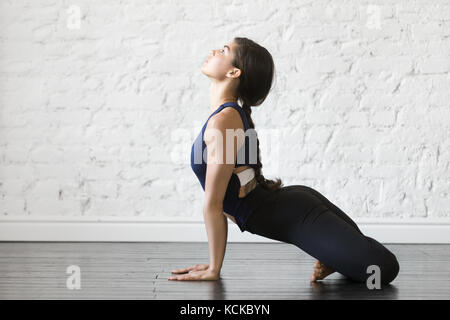 Junge Frau Üben Yoga, Stretching in den nach oben schauenden Hund mit padmasana Beine übung, Urdhva Mukha shvanasana darstellen, arbeiten, tragen sportswe Stockfoto