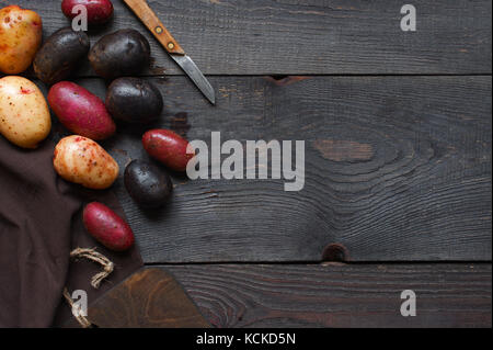 Küche aus Holz Hintergrund mit bunten Kartoffeln Stockfoto