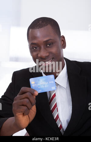 Portrait von Happy afrikanischen Geschäftsmann holding Kreditkarte Stockfoto