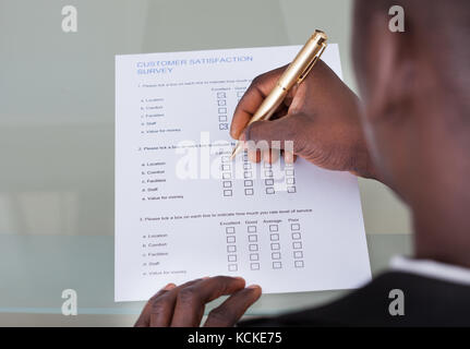 Nahaufnahme der Geschäftsmann Füllung Kundenfragebogen Stockfoto