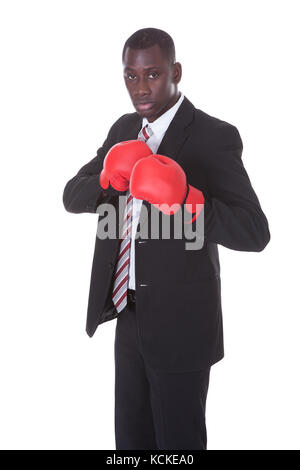 Afrikanische Unternehmer in Boxhandschuhen auf weißem Hintergrund Stockfoto