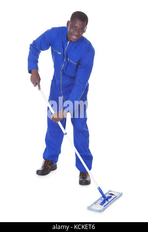 Junger Mann im blauen Anzug Reinigung des Bodens Over White Background Stockfoto