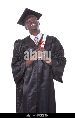 Porträt des jungen Graduierung Menschen beten Over White Background Stockfoto