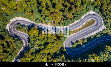 Geschwungene Straße durch den Wald. Pass in Siebenbürgen, Rumänien. Luftaufnahme von einer Drohne. Stockfoto