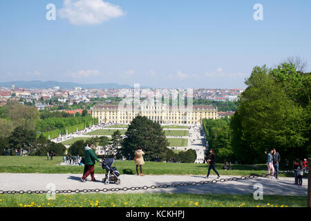 Wien, Österreich - Apr 30th, 2017: klassische Ansicht der berühmten Schloss Schönbrunn mit großem Parterre Garten mit Menschen zu Fuß an einem sonnigen Tag mit blauen Himmel und Wolken im Sommer. Der Palast ist eine ehemalige Kaiserliche 1441 - Zimmer Rokoko Sommerresidenz sissi Kaiserin Elisabeth von Österreich Stockfoto