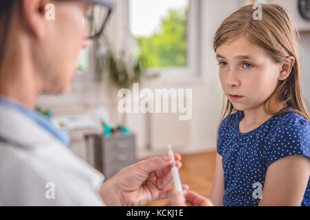 Kinderheilkunde Ärztin vorbereiten ein Impfstoff in einen Patienten zu spritzen Stockfoto