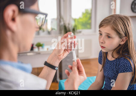 Kinderheilkunde Ärztin vorbereiten ein Impfstoff in einen Patienten zu spritzen Stockfoto