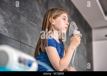 Kleine Mädchen in eine medizinische Inhalationstherapie mit einem Zerstäuber im Krankenhaus Stockfoto