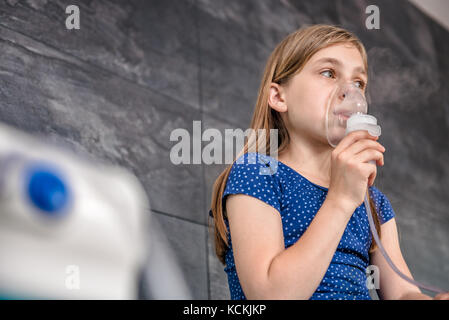 Kleine Mädchen in eine medizinische Inhalationstherapie mit einem Zerstäuber im Krankenhaus Stockfoto