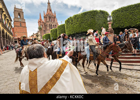 Mexikanischen Cowboys sind mit Weihwasser besprengt durch katholische Priester den Segen ihrer Wallfahrt während des Festivals von St. Michael in San Miguel de Allende, Mexiko. Stockfoto