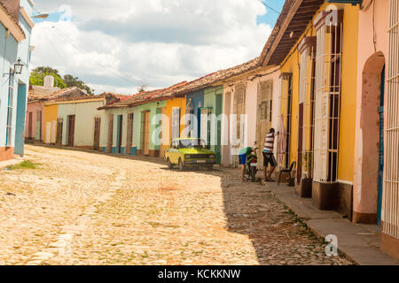 Street Scene alter amerikanischer Wagen geparkt Berufskranheiten bunte Häuser im Kolonialstil auf der Straße mit Kopfsteinpflaster, Trinidad, Kuba, Karibik, Stockfoto