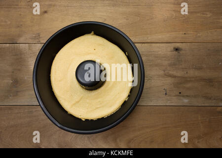 Kaffee-Baumwolle-Kuchen in schwarzer Kuchenform, verzehrfertig, auf rustikalem Holztisch, hausgemachter, flacher Laie Stockfoto