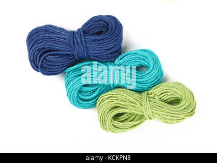 Gruppe von drei kleinen Spule Stränge der natürlichen Bunte multicolor Garn aus Jute Seil, Grün, Blau und Petrol, auf weißem Hintergrund, Nahaufnahme, erhöhen Stockfoto