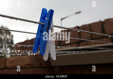 Blaue und weiße Klamotten hängen an einer nassen Wäscheleine. Tasmanien, Australien Stockfoto