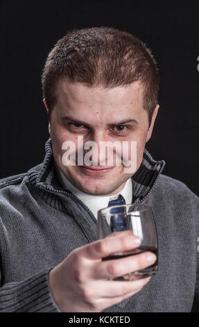 Mann mit einem Glas in der Hand, dunklen Hintergrund Stockfoto