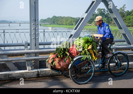 Ein Mann, sein Fahrrad beladen mit Bananen über Truong Tien Brücke (Cầu Trường Tiền) in Hue. Stockfoto