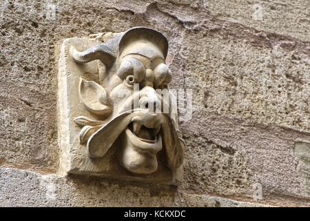 Grotesk geschnitzter Stein-Gargoyle-Kopf an einer Steinmauer Stockfoto