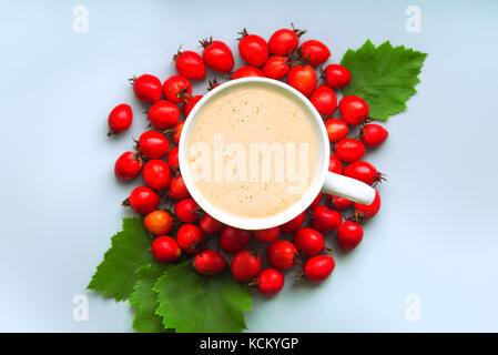 Kaffee in einer Tasse auf einem blauen Hintergrund mit berberitze Stockfoto