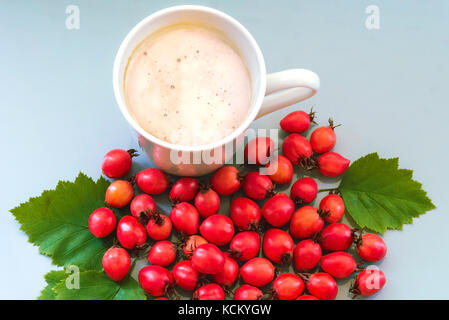 Kaffee in einer Tasse auf einem blauen Hintergrund mit berberitze Stockfoto