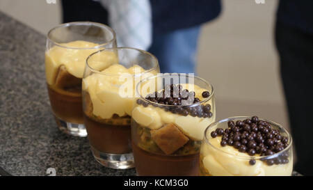 Kirschkäsekuchen auf dem Tisch. Serviert verschiedene Schokoladen- und Obstkuchen für den Urlaub, selektiver Fokus. Obstkuchen mit Beeren. Spinatschichtkuchen und Stapel französischer Makronen. Stockfoto