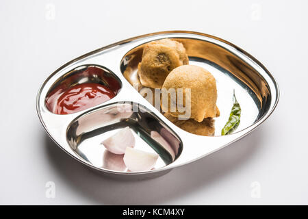 Aloo bonda, batate Vada oder alubonda - indische frittierte Junk, aber lecker essen oder Snacks in Edelstahl Teller über weißen Hintergrund mit Tomat Stockfoto