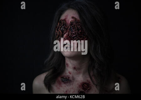 Mädchen mit realistischen Wunden und Würmer in den Augen. Kreative Halloween Make-up. Stockfoto