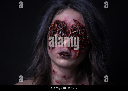 Mädchen mit realistischen Wunden und Würmer in den Augen. Kreative Halloween Make-up. Stockfoto