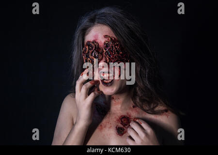 Mädchen mit realistischen Wunden und Würmer in den Augen. Kreative Halloween Make-up. Stockfoto